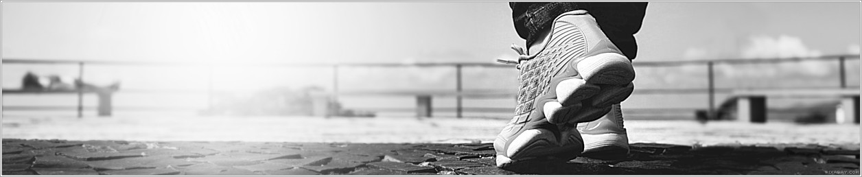 Foto von Schuhen an einer Strandpromenade aus der Froschperspektive aufgenommen.